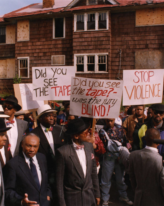 a group of protestors march with handmade signs