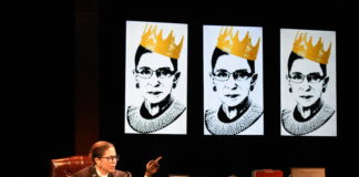 A woman sits at a desk, wearing the robes of a judge