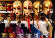 shelves displaying gold Venetian Carnival masks