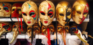 shelves displaying gold Venetian Carnival masks