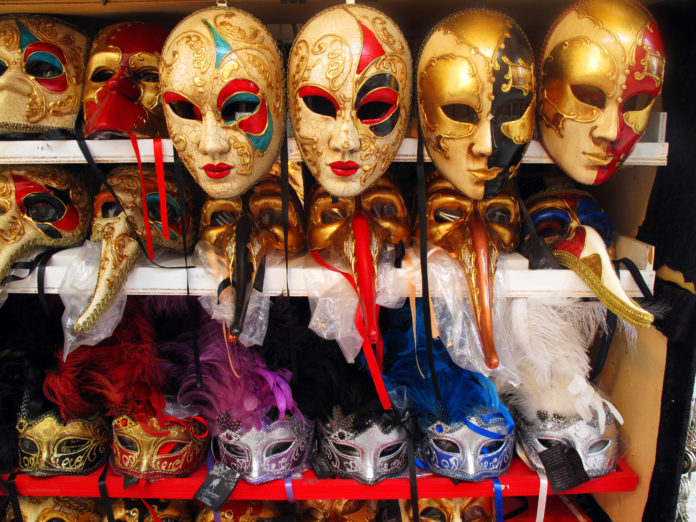 shelves displaying gold Venetian Carnival masks