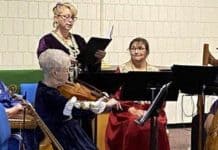 a woman sings, accompanied by a small group of instrumentalists