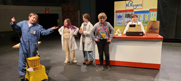 child actors onstage in front of scenery evoking a grocery store