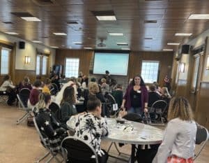 women sit at round tables and discuss business