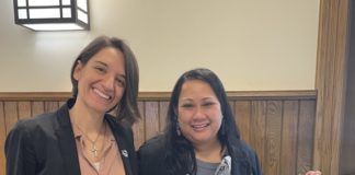 HerHub coordinator and Women of Toledo managing director stand at an event