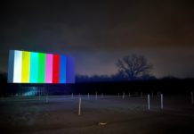 outdoor movie screen displays color bars against a dark sky