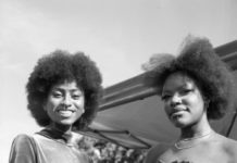 two young women stand in front of a tent at an outdoor festival