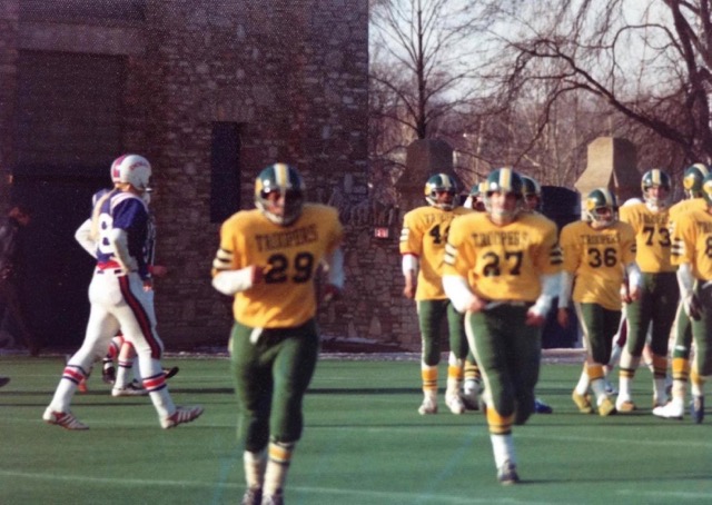 football players run across field