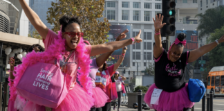 Two women in pink jump around