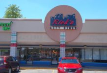 Photo of the front of Rick's diner with a red car parked in front.