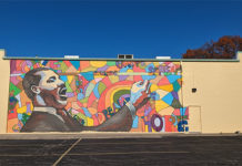 The wall that is to get the new mural currently with the one to be revised.