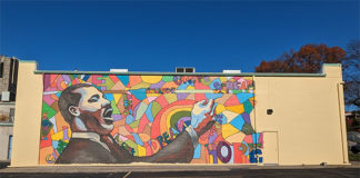 The wall that is to get the new mural currently with the one to be revised.