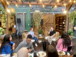 The Rotaract members, Isabella Weik (sitting left) and Alex Huffaker (sitting right) at the first Dinner Social event inside a cafe.