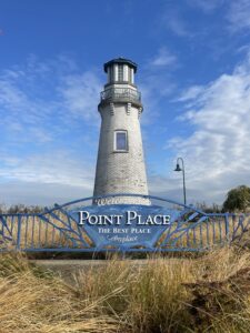 A wide shot of the Point Place Lighthouse with the sing in front.